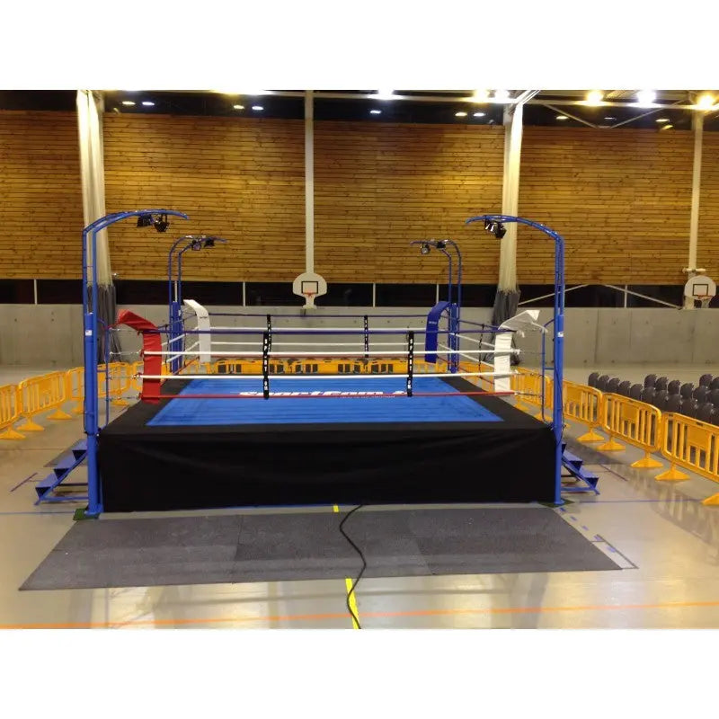 SportCom Pro-Wettkampf-Boxring mit 1 m Podium, in einer Halle mit Holzwand und Sitzreihen