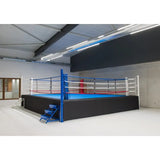 SportCom Pro-Wettkampf-Boxring mit 1 m Podium, in einer lichtdurchfluteten Halle, Seitenansicht