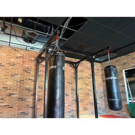 SportCom Proboxe Wandstation für Sandsäcke, vor Backsteinwand mit zwei Sandsäcken