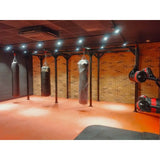 SportCom Proboxe Wandstation für Sandsäcke, in einem Gym mit orangefarbenem Boden und Spots
