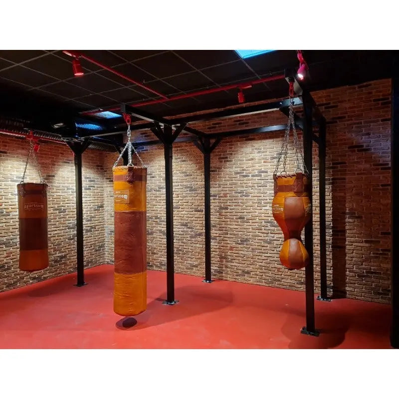 SportCom Proboxe Wandstation für Sandsäcke, mit Ledersäcken vor Backsteinwand