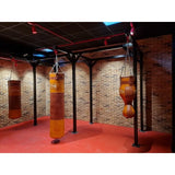 SportCom Proboxe Wandstation für Sandsäcke, mit Ledersäcken vor Backsteinwand