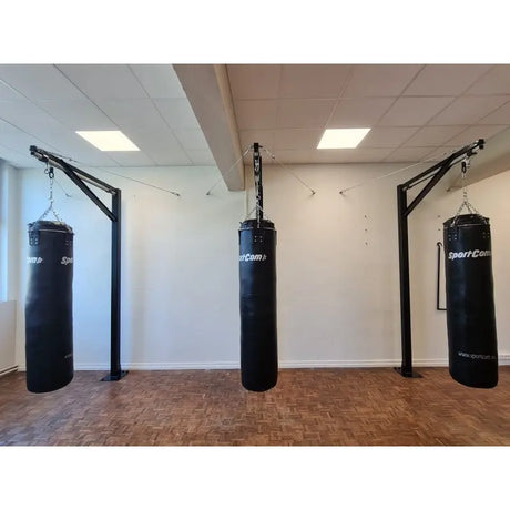 SportCom Professioneller Sandsackständer mit Schiene – Drei Ständer mit Sandsäcken auf Parkettboden im Trainingsraum