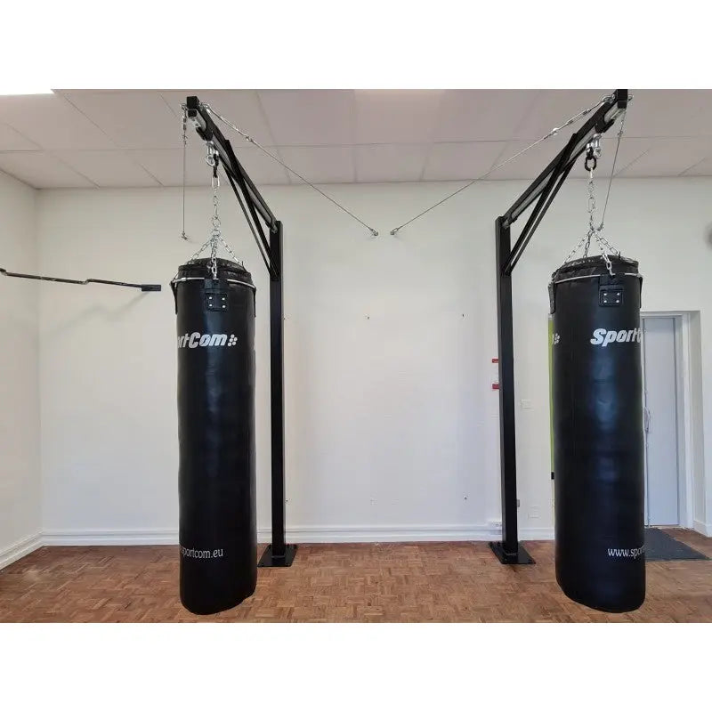 SportCom Professioneller Sandsackständer mit Schiene – Zwei Ständer mit schwarzen Sandsäcken an der Wand im Studio
