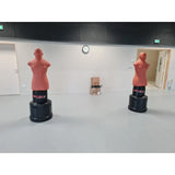 SportCom Punching-Dummy Bob verstellbar, zwei Trainingspuppen in einer hellen, leeren Trainingshalle
