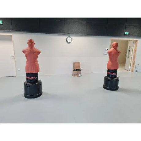 SportCom Punching-Dummy Bob verstellbar, zwei Trainingspuppen in einer hellen, leeren Trainingshalle