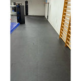 SportCom Puzzlematten 4 cm verlegt als dunkler Boden in einem Trainingsraum mit Sprossenwand