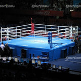 SportCom Ringplane 7,80 × 7,80 m für Wettkampfringe: Wettkampfring mit blauer Plane in einer abgedunkelten Arena