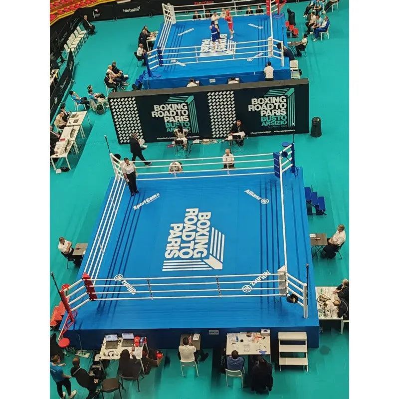 SportCom Ringplane 7,80 × 7,80 m für Wettkampfringe: Zwei Wettkampfringe mit blauen Planen in einer Halle, von oben