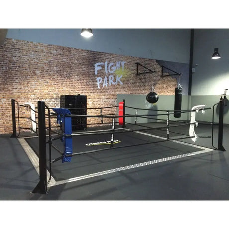 SportCom Ringplane für Bodenmontage-Boxringe – Schwarze Plane im Ring mit blauen und roten Ecken in der Halle
