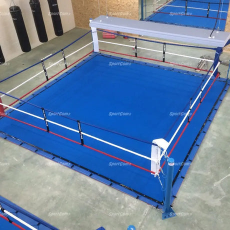 SportCom Ringplane für Bodenmontage-Boxringe – Blaue Plane mit roten Linien im Ring einer Halle, Draufsicht
