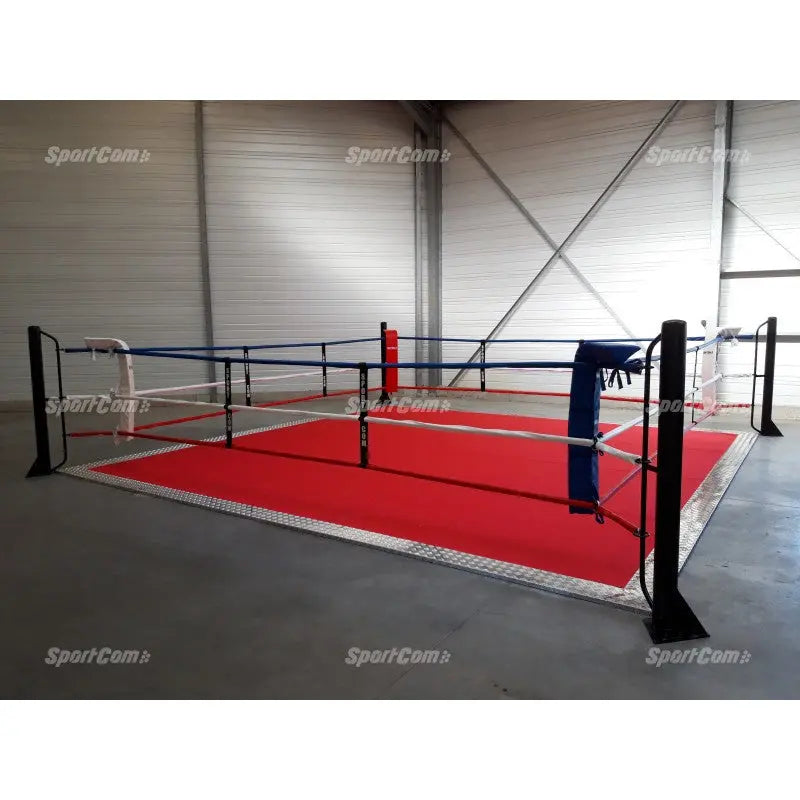 SportCom Ringplane für Bodenmontage-Boxringe – Rote Plane im Ring mit schwarzen Pfosten vor grauer Wand