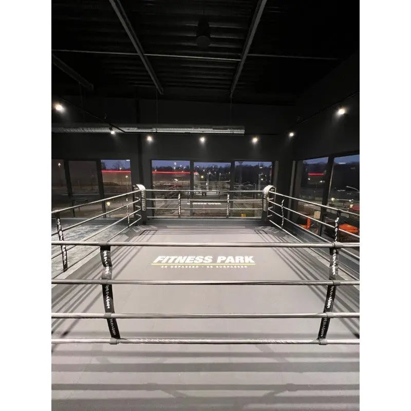 SportCom Ringplane für Podium-Trainingsringe – Graue Plane mit Aufdruck im Ring einer dunklen Halle