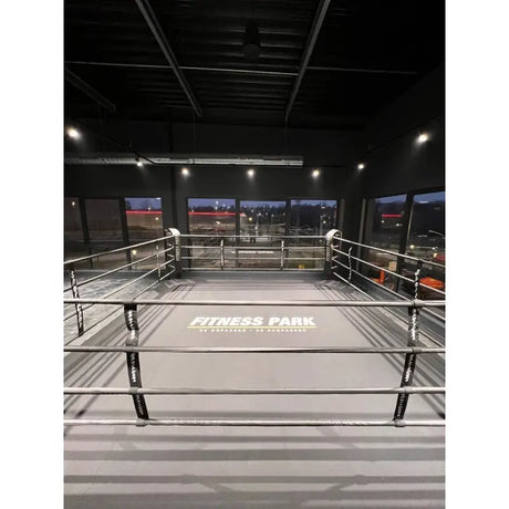 SportCom Ringplane für Podium-Trainingsringe – Graue Plane mit Aufdruck im Ring einer dunklen Halle