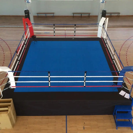 SportCom Ringplane für Wettkampf-Boxringe: Ring mit blauer Plane in einer Sporthalle mit Holzboden