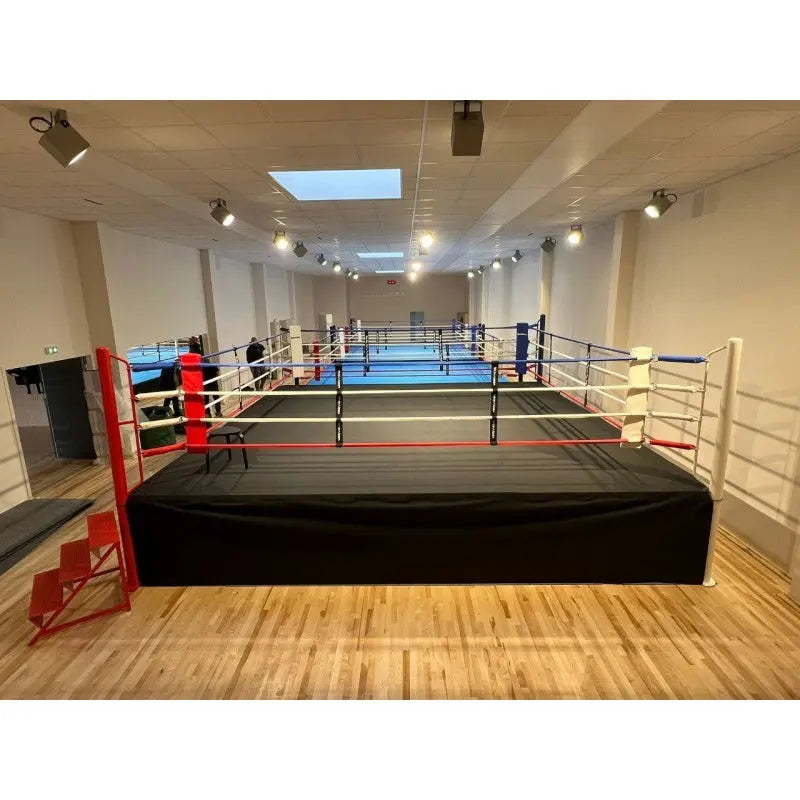 SportCom Ringplane für Wettkampf-Boxringe: Ring mit schwarzer Plane in einem hellen Trainingsraum