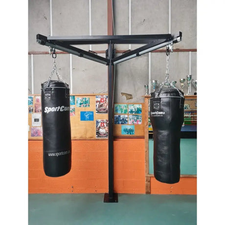 SportCom Sandsack-Wandhalterung mit Schiene und Laufwagen als freistehender Ständer mit zwei Sandsäcken vor oranger Wand