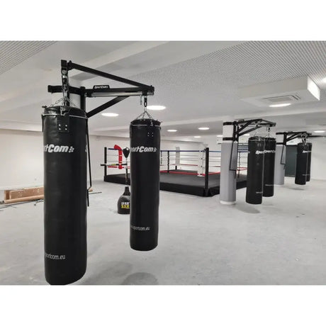 SportCom Sandsack-Wandhalterung mit Schiene und Laufwagen mit zwei Sandsäcken vor Boxring und weiteren Stationen