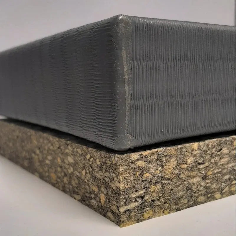 SportCom Schaumstoffunterlage für Tatami 3 cm: Kante der Verbundschaumplatte unter einer grauen Tatami, Nahaufnahme