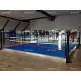 SportCom Trainingsboxring mit 15 cm Podium, in einer großen Halle mit blauem Boden