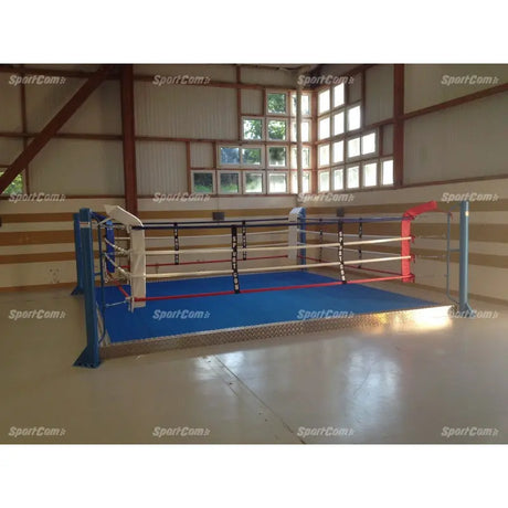 SportCom Trainingsboxring mit 15 cm Podium, in einer Halle mit Holzwand und blauem Boden