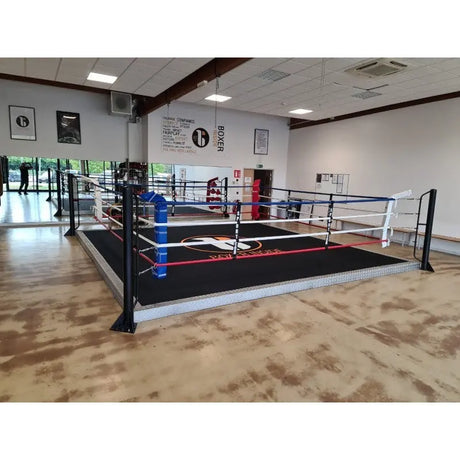 SportCom Trainingsboxring mit 15 cm Podium, in einer Halle mit Parkett und schwarzem Boden