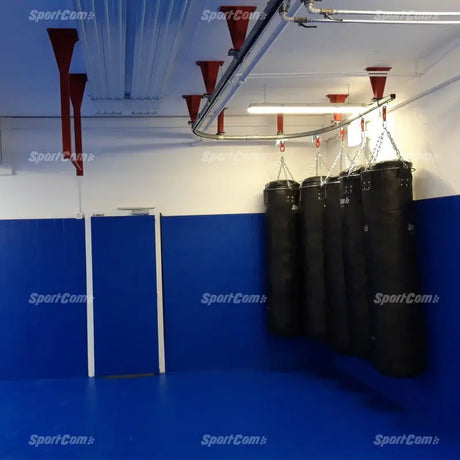 SportCom Überkopf-Förderschiene für Sandsäcke, in einem Raum mit blauen Wandmatten