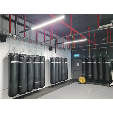 SportCom Überkopf-Förderschiene für Sandsäcke, mit Sandsackgruppen entlang einer grauen Wand