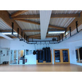 SportCom Überkopf-Förderschiene für Sandsäcke, in einer Halle mit Holzträgern und weißen Wänden