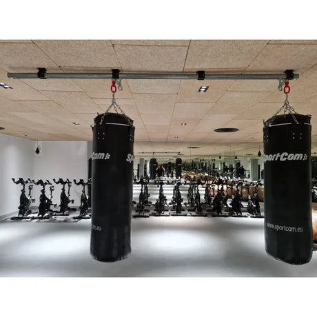 SportCom Überkopf-Förderschiene für Sandsäcke, in einem Studio mit Indoor-Bikes im Hintergrund