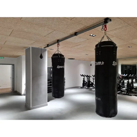 SportCom Überkopf-Förderschiene für Sandsäcke, im Studio zwischen weißen Säulen, Sandsack vorn