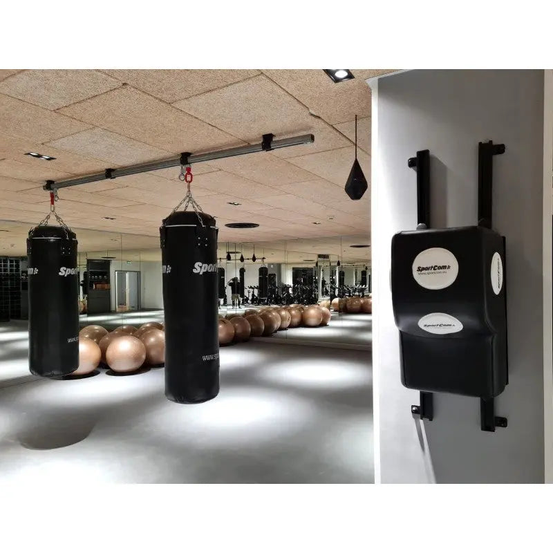 SportCom Uppercut-Ziel verstellbar: Polster an einer Säule neben Sandsäcken in einem Trainingsraum