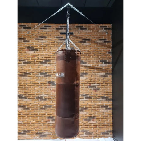 SportCom Vintage-Sandsack Echtleder 1,30 m hängend vor einer Backsteinwand in dunkelbraun
