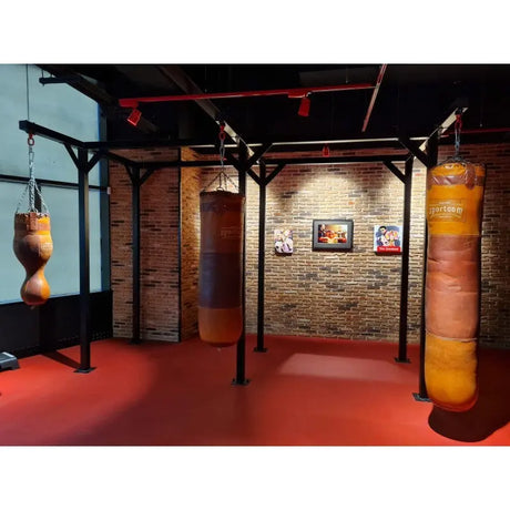 SportCom Vintage-Sandsack Echtleder 1,30 m in einem Studio mit rotem Boden in weiter Übersicht