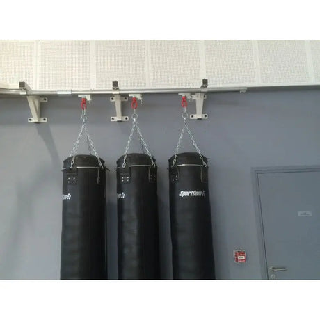 SportCom Wandmontierte Schiene für Sandsäcke, mit drei Sandsäcken vor grauer Wand, Nahansicht