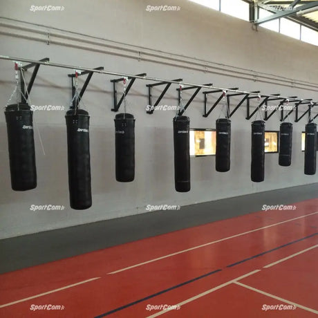 SportCom Wandmontierte Schiene für Sandsäcke, in einer Sporthalle mit vielen Sandsäcken an der Wand