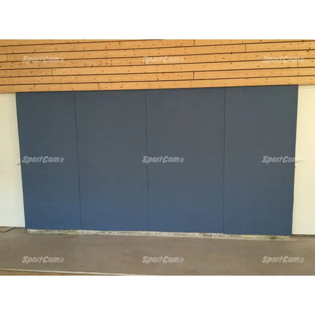 SportCom Wandpolster Standard, blaugraue Polster an einer Holzwand, Frontansicht