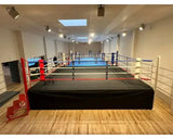 SportCom Wettkampf-Boxring mit 1 m Podium, in einer hellen Halle mit Holzboden
