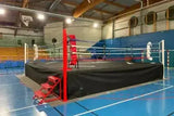 SportCom Wettkampf-Boxring mit 1 m Podium, mit roter Treppe in einer Sporthalle