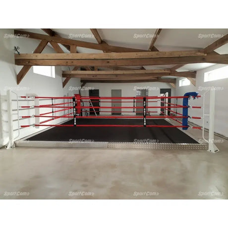 SportCom Wettkampf-Boxringseil mit Hülle, Bodenring mit roten Seilen und blauer Ecke unter Dachbalken