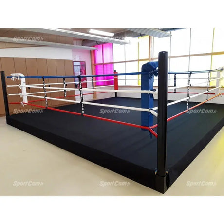 SportCom Wettkampf-Boxringseil mit Hülle, erhöhter Boxring mit roten und weißen Seilen in heller Halle