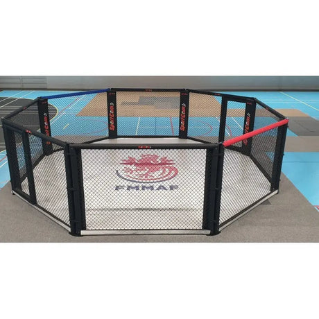 SportCom Wettkampf-MMA-Käfig 7 m auf Podium, Frontansicht in der Halle mit FMMAF-Logo auf der Matte
