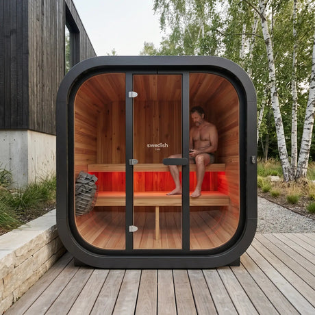 Swedish Cold Grand Lodge Außensauna, auf einer Holzterrasse mit Person im Innenraum