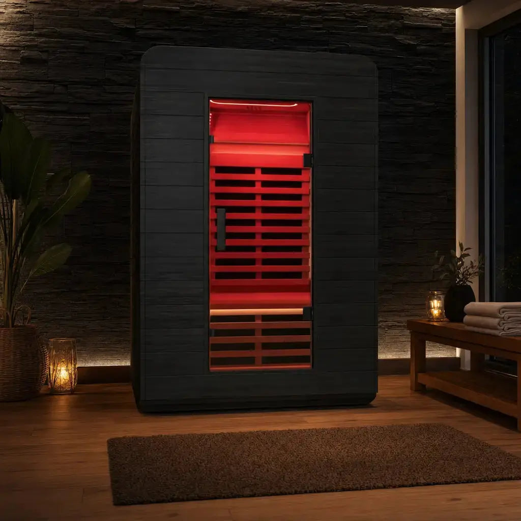 Swedish Cold Ultimate Lux Infrarotsauna in einem dunklen Wohnraum mit Pflanzen und Kerzen, rot beleuchtet