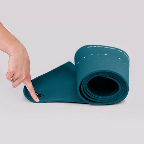 tiguar Yoga-Basismatte Marine Yogamatte, aufgerollt, Finger zeigt auf die Markierungslinie