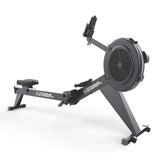 Titanium Strength Air Rowing Machine Rudergerät in Schrägansicht von vorn mit Monitorarm und Fußstützen