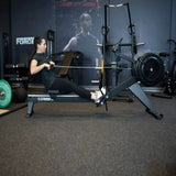 Titanium Strength Air Rowing Machine Rudergerät im Studio beim Rudertraining einer Sportlerin in der Zugphase