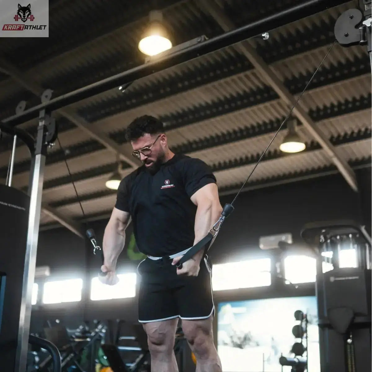 Titanium Strength Black Series 2-Station Cable Crossover, Mann beim Training am unteren Seilzug im Studio