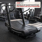 Titanium Strength Curved RS Laufband in einem fertig eingerichteten Studio mit dunklen Wänden und Gummiboden
