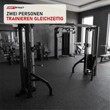 Titanium Strength Elite Series 2-Station Cable Crossover in einem fertig eingerichteten Studio mit dunklen Wänden und Gummiboden